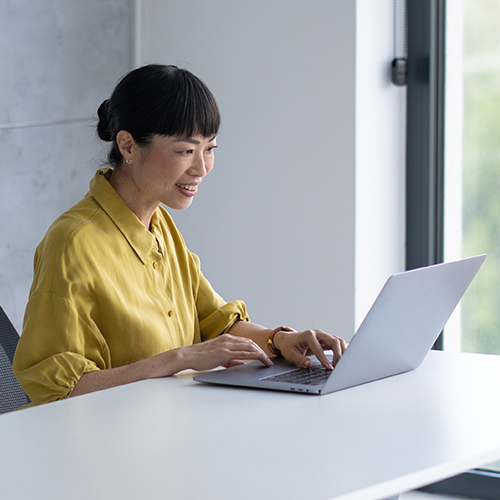 woman sitting at a desk typing on a laptop