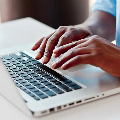 close up of hands typing on a laptop