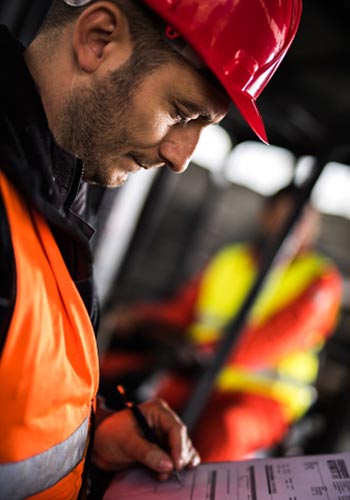fire inspector looking filling out report on clipboard