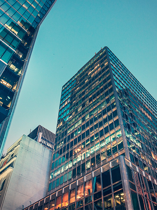 Looking up at tall buildings and seeing blue sky