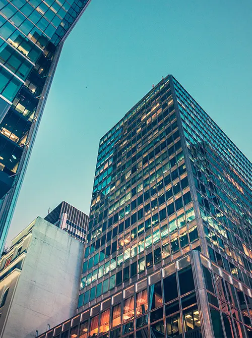 Looking up at tall buildings and seeing blue sky