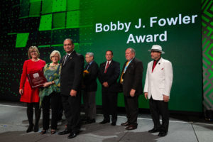 Previous recipients of the Bobby J. Fowler Award join Burton’s wife Linda (second from left) and daughter Shelly (left) to accept the posthumous award from Board Immediate Past President Jay Elbettar (third from left).