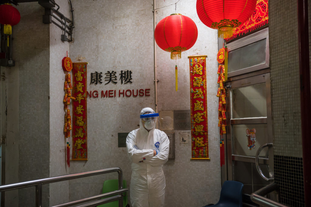 An official wearing protective gear stands guard outside an entrance to the Hong Mei House residential building at Cheung Hong Estate in Hong Kong on Feb. 11, 2020, following the evacuation of more than 100 people from the housing block after residents in two different apartments tested positive for the new coronavirus. Image: Getty Images