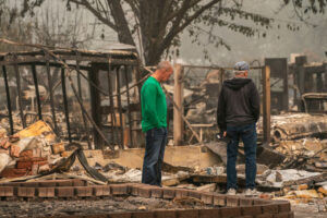 Homeowners survey their property in a neighborhood destroyed by wildfire in Talent, Oregon. Hundreds of homes in Talent and nearby towns have been lost due to wildfire. Photo: by David Ryder/Getty Images