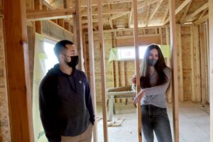 Alyssa Stone (right) standing in a house being built by CTEC students. The house was designed by a previous student.