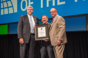 Bob Schutz (center) receives the 2019 Educator of the Year Award from Committee Chairman Alan Boswell (left) and Code Council Board Immediate Past President William Bryant (right) during the ICC Members Luncheon on Oct. 22, 2019, in Las Vegas, Nev.