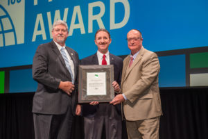 Jeff Shapiro (center) receives the 2019 ICC Fire Service Award from Committee Chairman Alan Boswell (left) and Code Council Board Immediate Past President William Bryant (right) during the ICC Members Luncheon on Oct. 22, 2019, in Las Vegas, Nev.