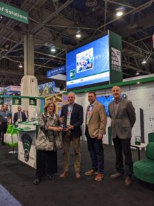 Dominic Sims, alongside Michael Wich, ICC Board President, and Shahin Moinan, Executive Vice President, Conformity Assessment Group, accepting the plaque on behalf of the Code Council.